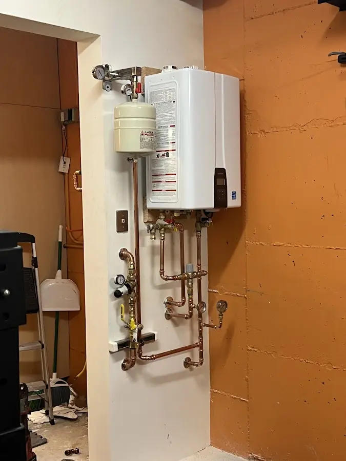 Plumbing technician inspecting water heater connections in Burnsville